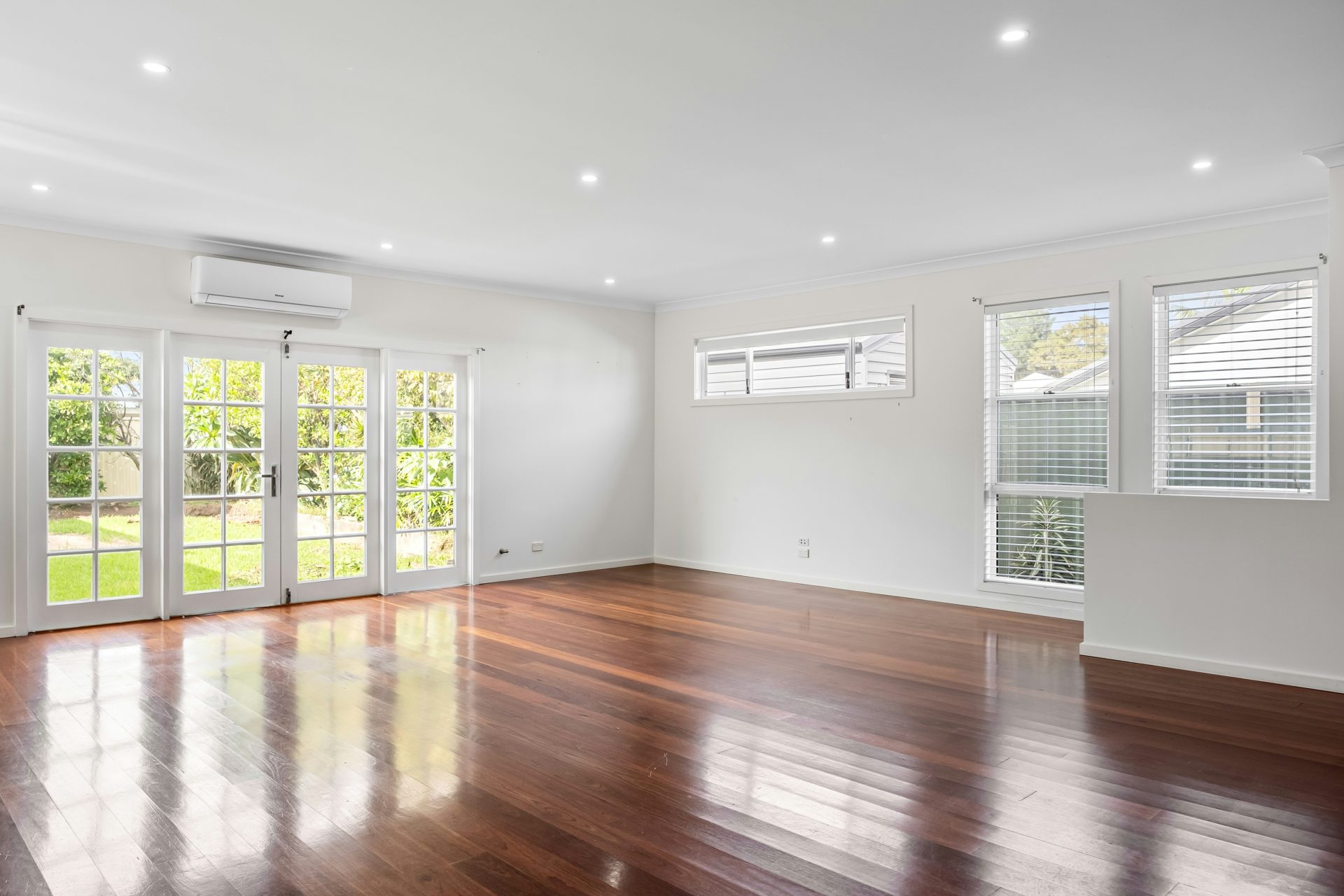An empty living room with hard wood floors