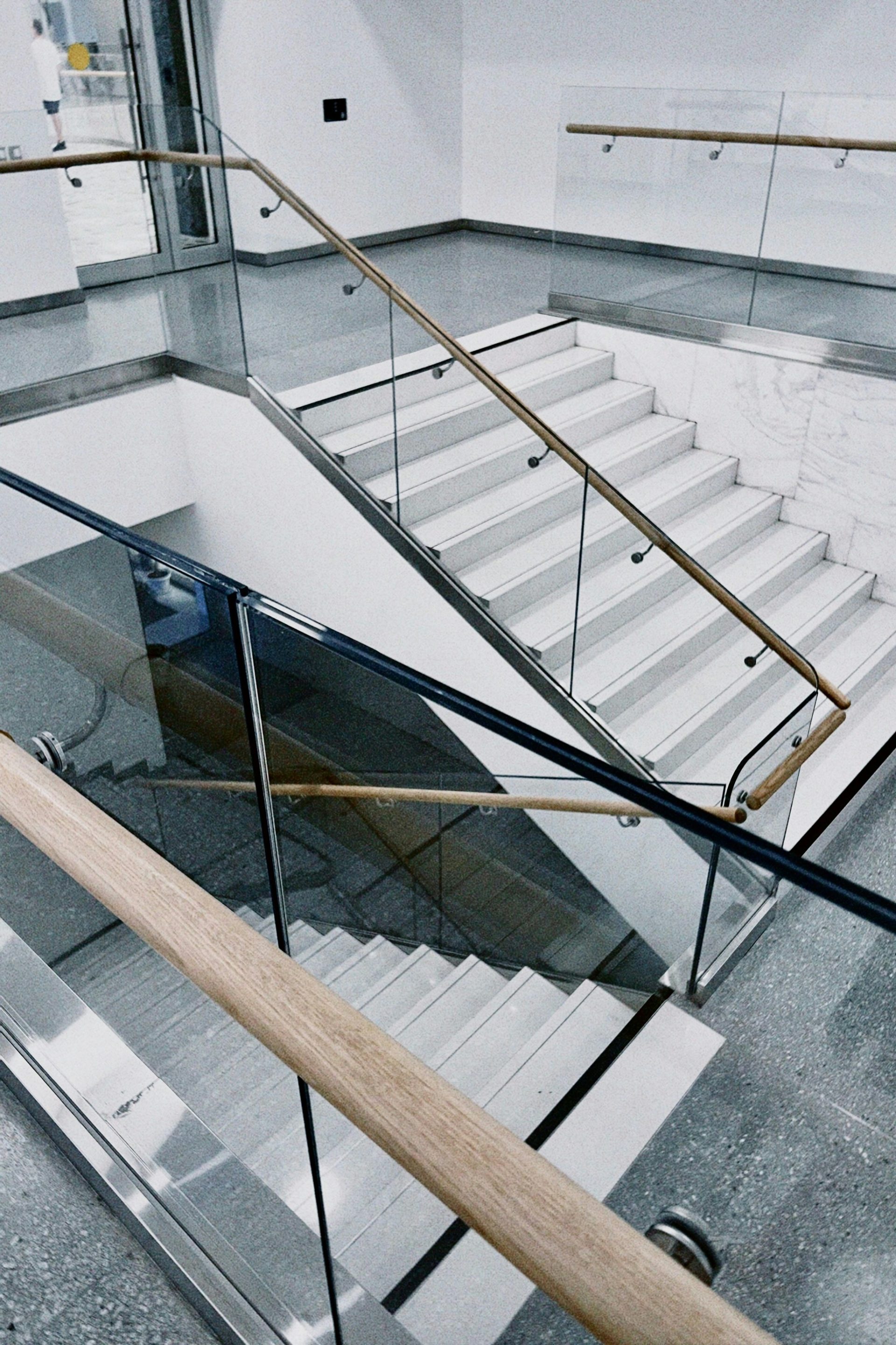 a glass staircase with a wooden hand rail